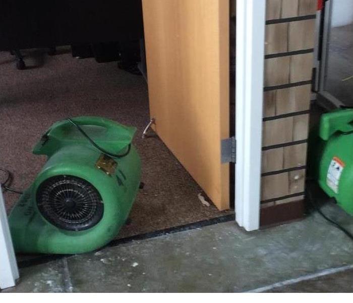 room with door open in an office being dried out by SERVPRO equipment